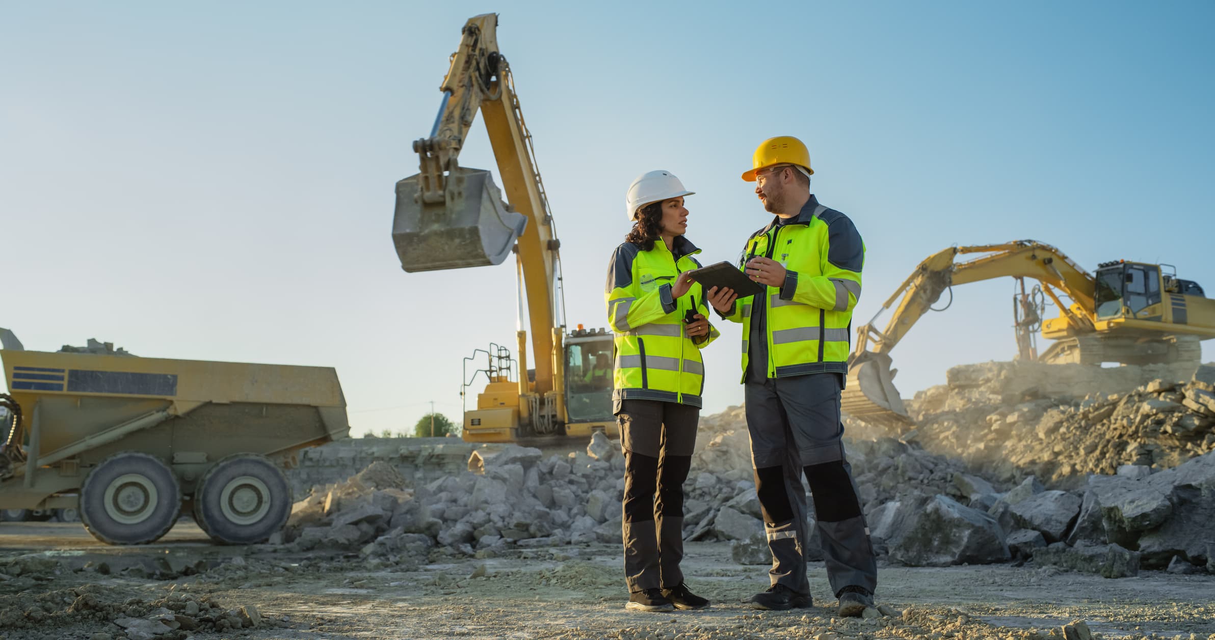 Construction professionals reviewing work at an active heavy-equipment site